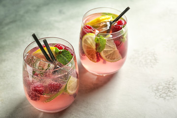 Glasses of fresh raspberry mojito on light table