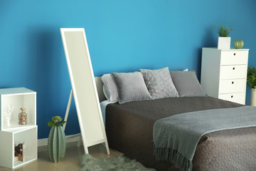 Interior of stylish room with mirror near color wall