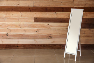 Large mirror near wooden wall