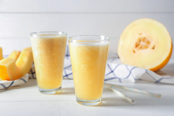Glasses of delicious melon smoothie on white table