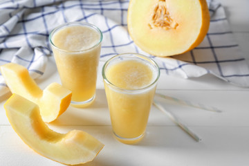 Glasses of delicious melon smoothie on white table