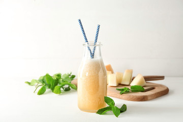 Bottle with delicious melon smoothie on white table