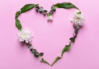 Obraz premium Heart made of beautiful flowers and leaves on color background