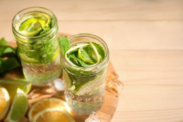 Jars of fresh mojito on wooden table