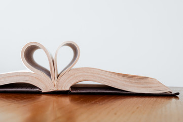 vintage style, close up heart shape from paper book on wooden table