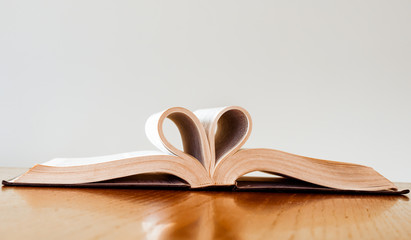 vintage style, close up heart shape from paper book on wooden table