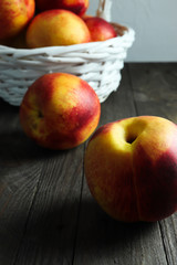 Group of ripe nectarines and a basket in the background