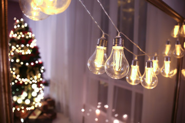 Glowing Christmas garland hanging on mirror