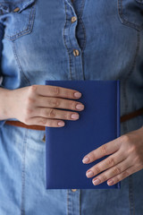 Woman with professional manicure holding notebook, closeup