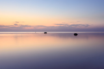 Obraz premium The sky is reflected in the sea at sunset on a long exposure.