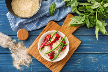Plate with tasty boiled rice and vegetables on wooden table