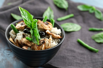 Bowl with tasty boiled rice and vegetables on table