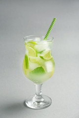 Glass of fresh cocktail on grey background