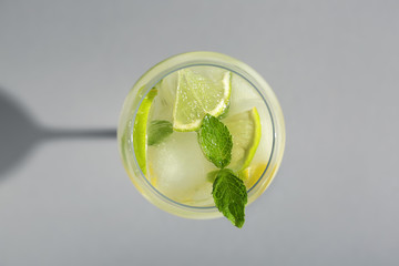 Glass of fresh cocktail on grey background