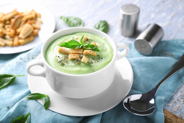 Pot with delicious zucchini soup on table