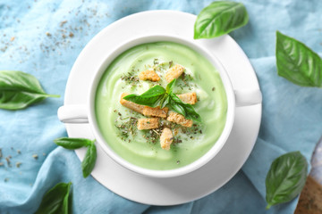 Pot with delicious zucchini soup on table