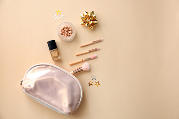 Set of cosmetics with bag and decorations on color background