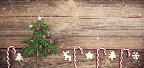 christmas tree on wooden board with candy canes and wooden decorations