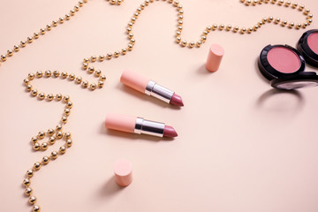 Set of cosmetics with beads on color background