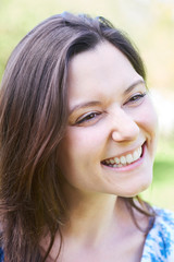 Outdoor Head And Shoulders Portrait Of Laughing Young Woman