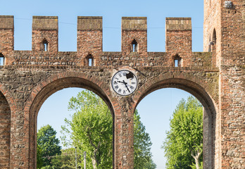 Detail of the walls and broken clock of a medieval village.