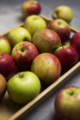 Apples in wooden tray at gray background