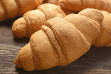 Tasty croissants on wooden table