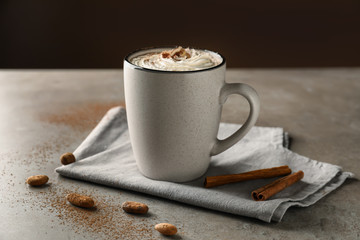 Cup of delicious cocoa on grey table
