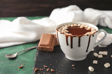 Cup of delicious cocoa and sweets on slate plate
