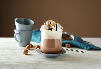 Cup of delicious cocoa with marshmallows on light wooden table