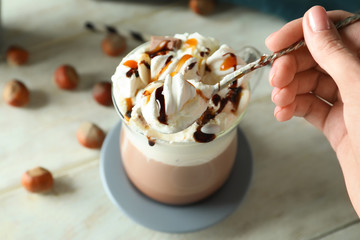 Woman eating marshmallows from cup with delicious cocoa, closeup