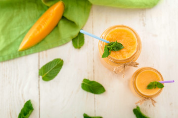 Jars of fresh melon smoothie on white  table