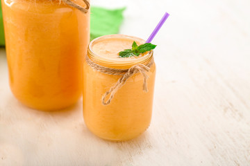 Jars of fresh melon smoothie on white  table