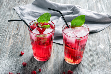 Glasses of fresh raspberry lemonade on wooden table