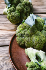 Plate with ripe broccoli on wooden table