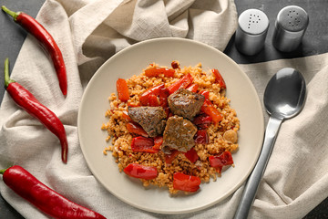 Plate with boiled rice, meat and pepper on table