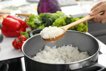 Woman cooking rice in kitchen, closeup