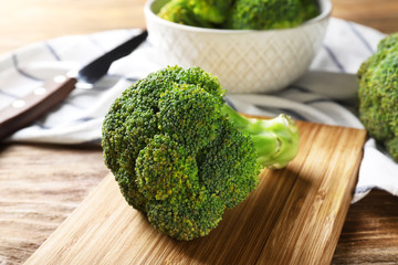 Board with fresh green broccoli on wooden table, closeup