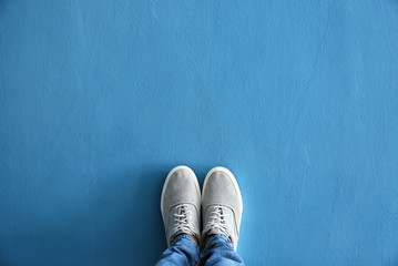 Legs of man in casual shoes on color background - obrazy, fototapety, plakaty