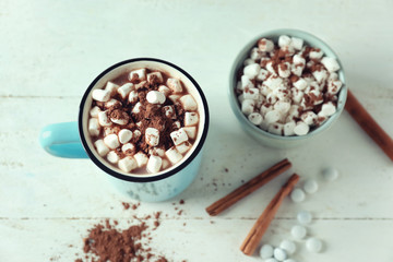 Cup of tasty cocoa and marshmallows on white table