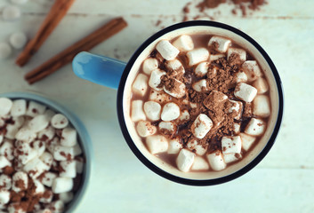 Cup of tasty cocoa and marshmallows on white table