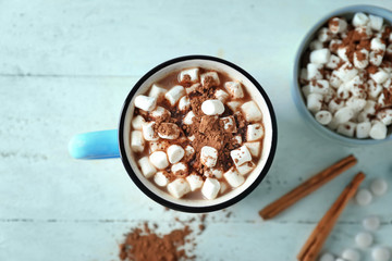 Cup of tasty cocoa and marshmallows on white table