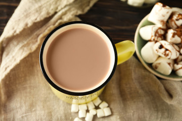 Cup of tasty cocoa and marshmallows on table