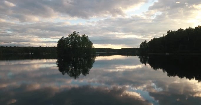 An aerial footage of a calm lake during sunset in lakeland finland.