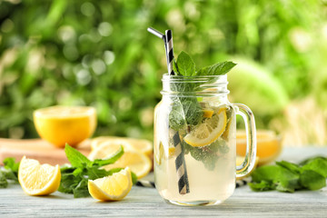 Mason jar of fresh lemonade on table