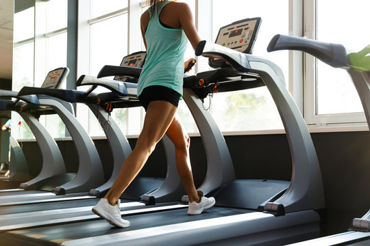 Cropped image of sports woman training on treadmill