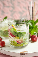 Glass of fresh strawberry lemonade on wooden board