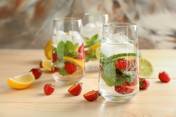 Glasses of fresh strawberry lemonade on wooden table