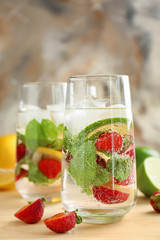 Glasses of fresh strawberry lemonade on wooden table