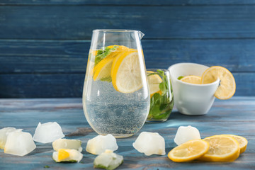 Jug of fresh lemonade on wooden table